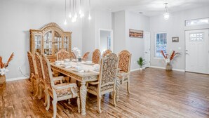 A dining area with a large wooden table, ornate chairs, and a mirror cabinet. - Updated, dog-friendly gem w/fenced yard, foosball & pool tables, WiFi, fireplace (St. Augustine)