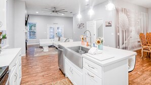 A modern kitchen with white cabinetry, a built-in dishwasher, and pendant lighting. - Updated, dog-friendly gem w/fenced yard, foosball & pool tables, WiFi, fireplace (St. Augustine)