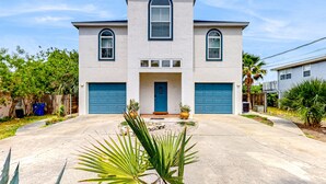 A two-story house with a central entrance, two garage doors, and a symmetrical facade.