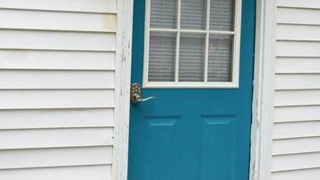 Une maison blanche avec une porte bleue et une fenêtre blanche.