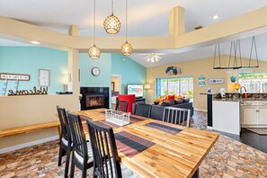 A spacious living area with a dining table, chairs, a sofa, and a kitchen area with a countertop and sink.