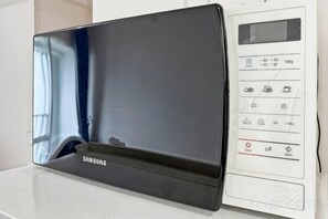 En Samsung mikrobølgeovn med digitalt display og betjeningspanel.