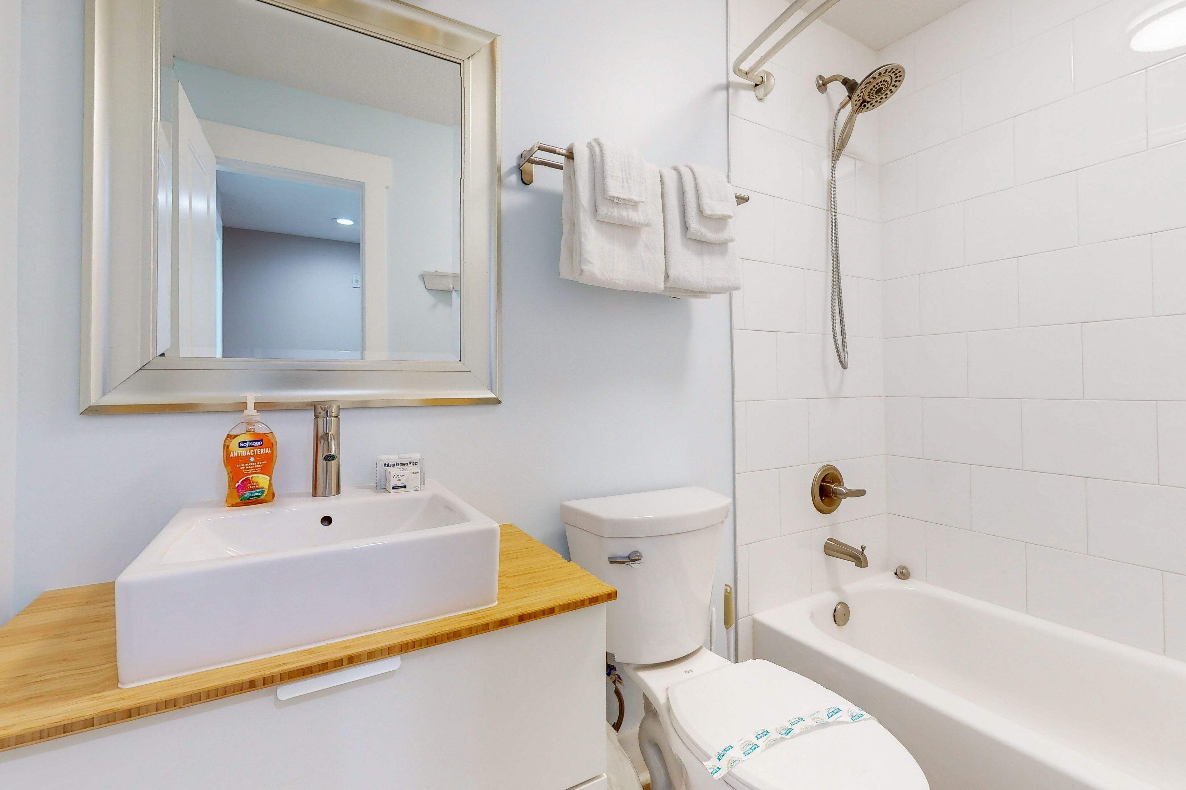 A bathroom with a white sink, toilet, and bathtub.