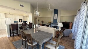 A spacious living area with a dining table, chairs, a sofa, and a TV. - Spacious condo with pool, hot tub and private washer/dryer (St. Augustine)