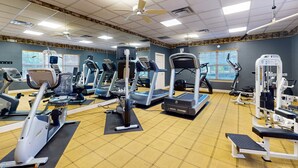 A gym with various exercise equipment, including treadmills, elliptical machines, and weight machines. - Spacious condo with pool, hot tub and private washer/dryer (St. Augustine)