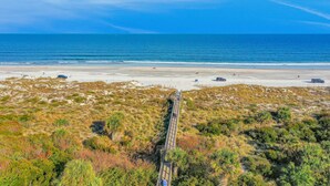 A coastal road leading to a beach with a clear view of the ocean.