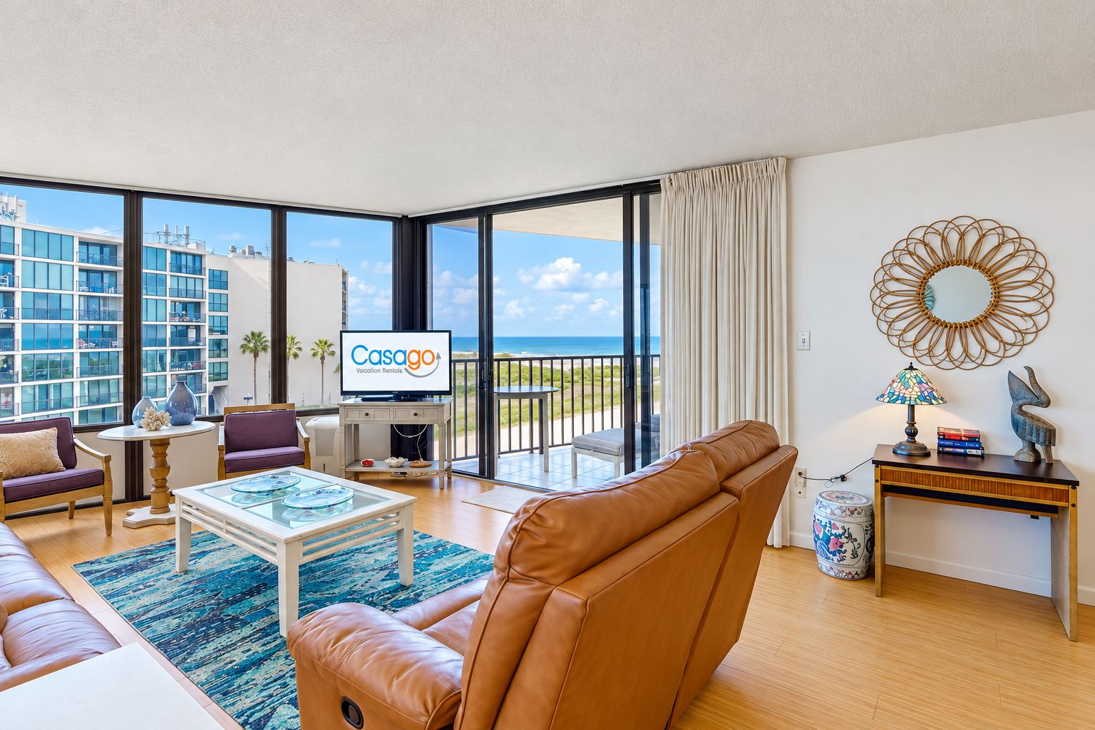 Una sala de estar moderna con un sofá, una mesita de centro y un televisor mostrando 'Casago Vacation Rentals'.