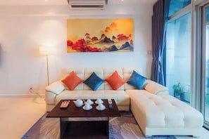 A modern living room with a sofa, a coffee table, and a painting on the wall.