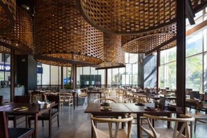 A spacious restaurant with high ceilings and natural light. Tables are arranged in a casual layout, and the interior features wooden furniture and a modern design. - Salute de Sailing Tower - Palace Garden District 1 (Ho Chi Minh City)