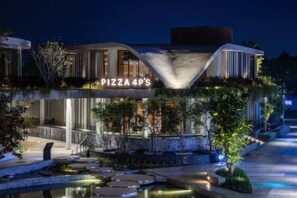 A modern building with a unique architectural design, featuring a prominent 'PIZZA 4P'S' sign. - Salute de Sailing Tower - Palace Garden District 1 (Ho Chi Minh City)