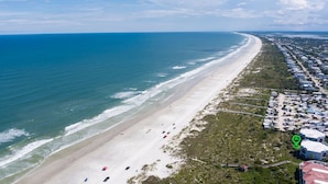 An aerial view of a coastal area with a beach, houses, and a road. - Lovely ocean-view condo with pools, hot tubs, private W/D, & central AC (St. Augustine)