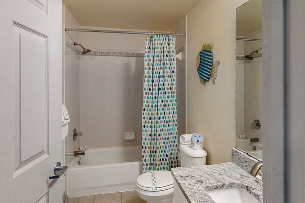 A bathroom with a bathtub, toilet, and sink.