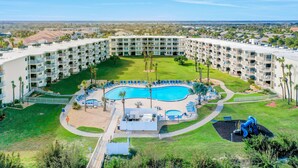A resort with a central pool, multiple balconies, and a well-maintained lawn. - Ground-floor condo next to the tennis courts with 2 pools, sauna, beach access (St. Augustine)