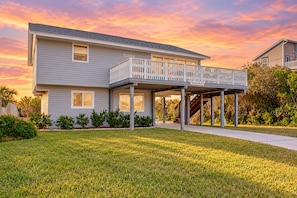 A two-story house with a covered porch and a balcony.