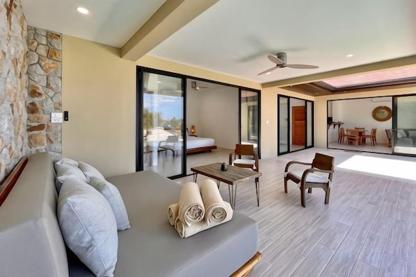 A modern living area with a sofa, chairs, a table, and a balcony with a view. - Villa Marie, 2 Bedrooms, Lamai Koh Samui (Koh Samui)