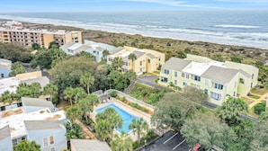 Zona residencial com piscina, casas e vista para o mar.