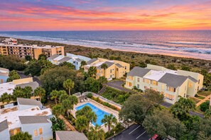 A coastal residential area with multiple two-story houses, a swimming pool, and a view of the ocean.