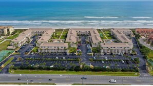 A large hotel complex with multiple buildings, a parking lot, and a view of the ocean. - Crescent Beach Retreat, Partial Ocean View, Heated Pool, Tennis & Pickleball (St. Augustine)