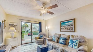 A living room with a ceiling fan, a sofa set, a coffee table, and a television. - Newly remodeled ground-floor condo w/on-site pools, 5 hot tubs, tennis, AC (St. Augustine)
