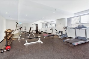 Une salle de sport équipée de tapis de course, de vélos elliptiques et de matériel de musculation.