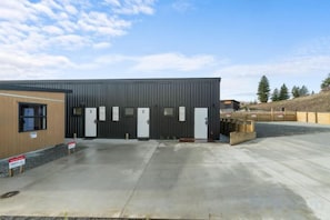 A building with a large parking area, multiple doors, and a clear sky. - Sunshine Suites (Lake Tekapo)