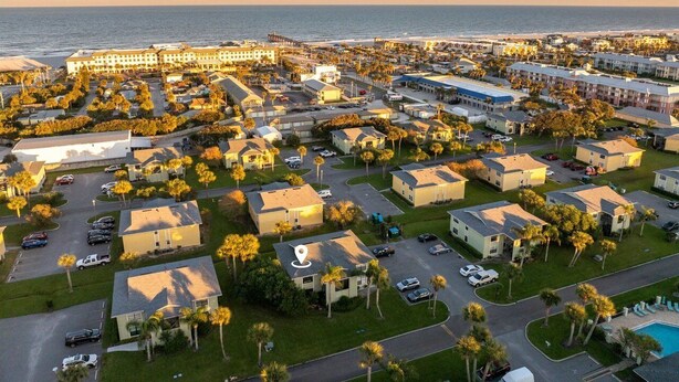A coastal resort with multiple bungalow-style buildings, a central parking area, and a view of the ocean. - Colorful condo w/shared pool, free WiFi, central A/C - blocks from the beach (St. Augustine)