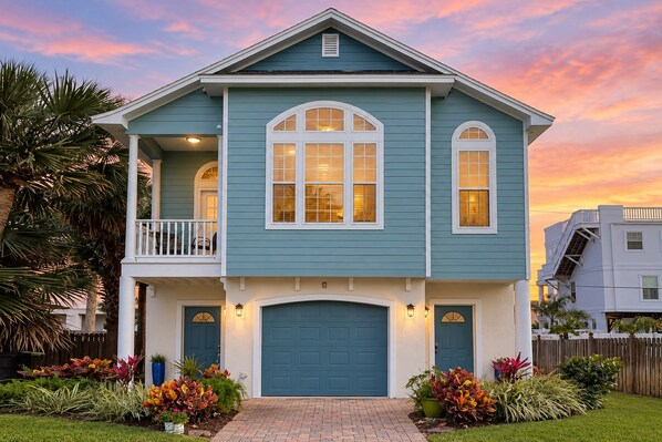 A two-story house with a front porch, a garage, and a balcony. - Two-level home with partial ocean view, balcony, WiFi, & W/D - walk to the beach (St. Augustine)
