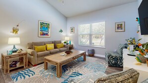 A living room with a sofa, coffee table, and decorative items.