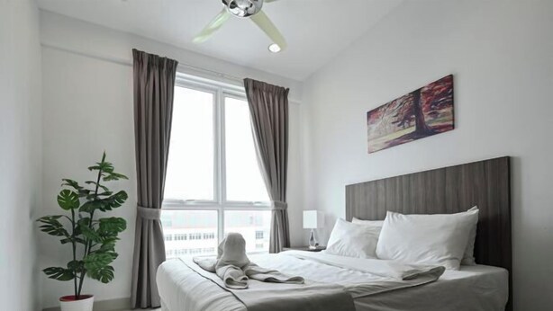 A hotel room with a bed, a potted plant, a window with curtains, a painting on the wall, and a ceiling fan. - Mansion One Suites by Simply Penang (George Town)