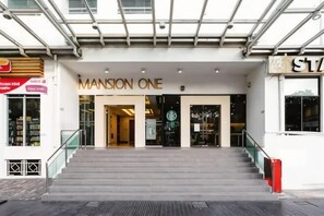 A hotel entrance with a staircase leading up to the doors, a sign reading 'Mansion One,' and a glass ceiling above. - Mansion One Suites by Simply Penang (George Town)