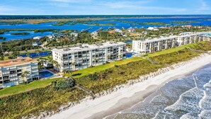 A beachfront hotel with multiple buildings, a swimming pool, and a beach. - Oceanfront condo with pool, ocean views, and washer/dryer (St. Augustine)
