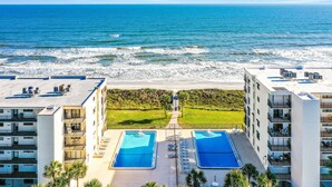 A beachfront hotel with two swimming pools, a beach view, and a well-maintained lawn. - Oceanfront condo with pool, ocean views, and washer/dryer (St. Augustine)