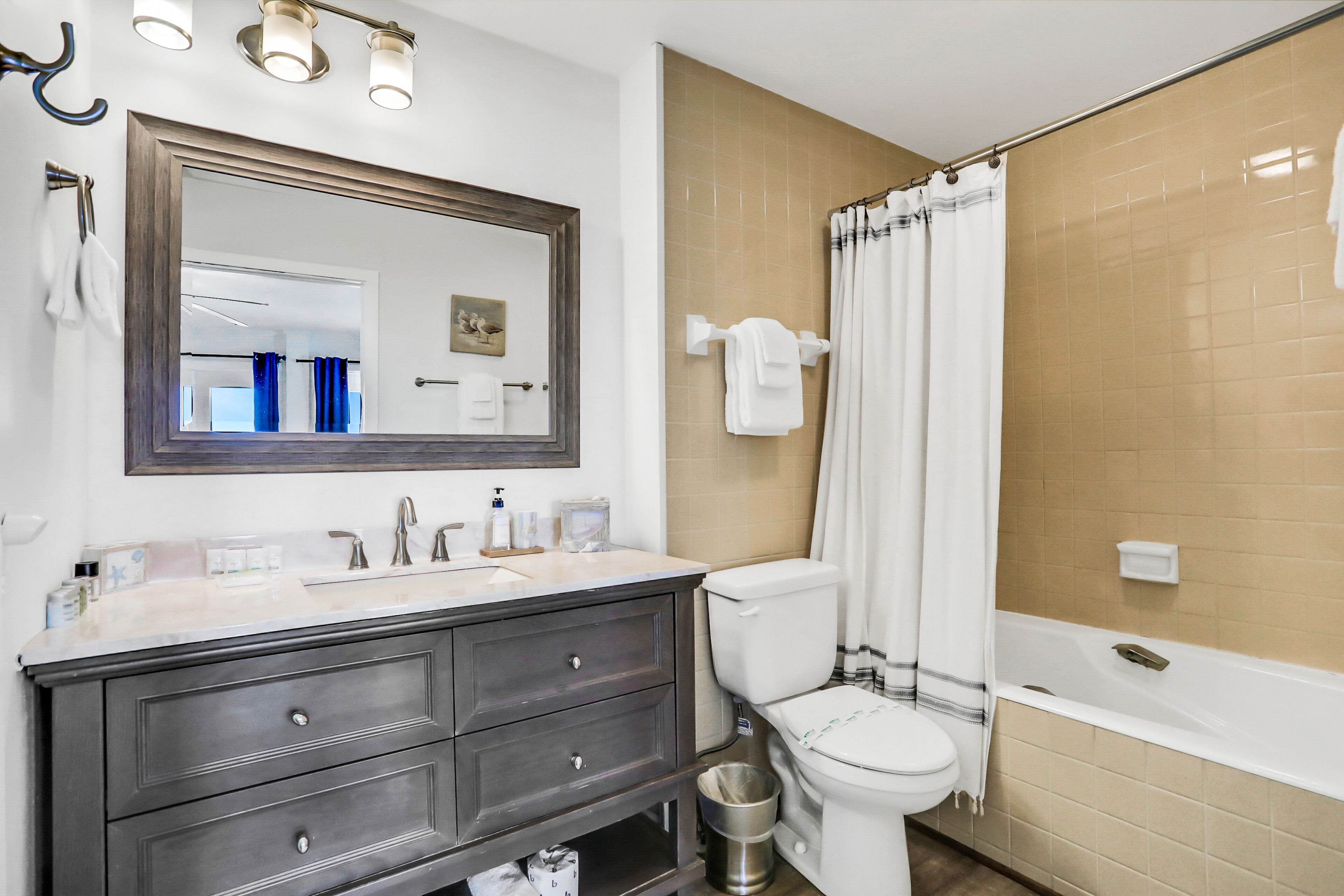 Ein Badezimmer mit Waschbecken, Spiegel, Toilette und Badewanne.