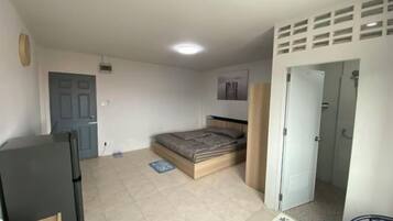A bedroom with a bed, a wardrobe, a door, and a small table.