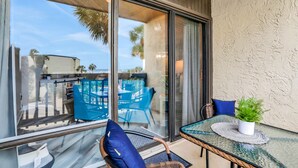 Ein Balkon mit Glastisch, Stühlen und einem Blumentopf.