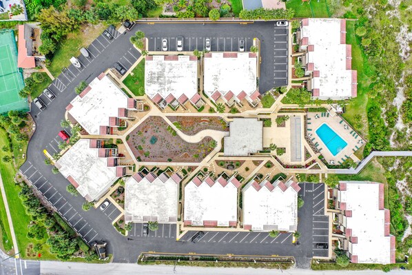 An aerial view of a hotel with multiple buildings, parking lots, and a swimming pool. - Modern oceanview condo with multiple balconies, pool & W/D - beach access (St. Augustine)