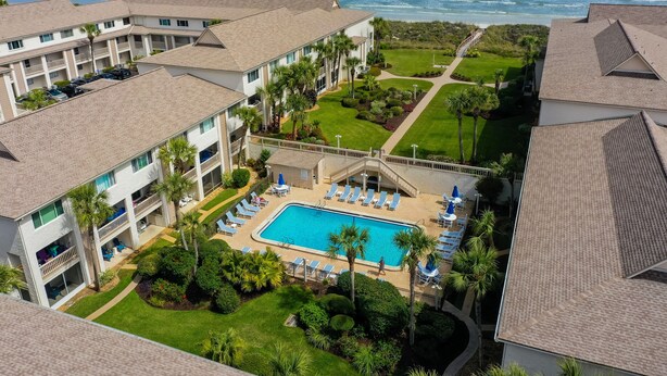 Um resort com piscina, várias varandas e vista para o oceano.