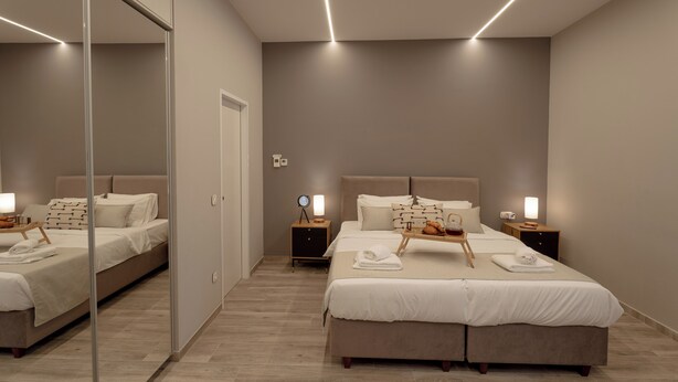 A modern bedroom with a large bed, bedside tables, a mirror, and a nightstand. - Athens Soho Lofts - Evagelistrias Pedestrian (Athens)