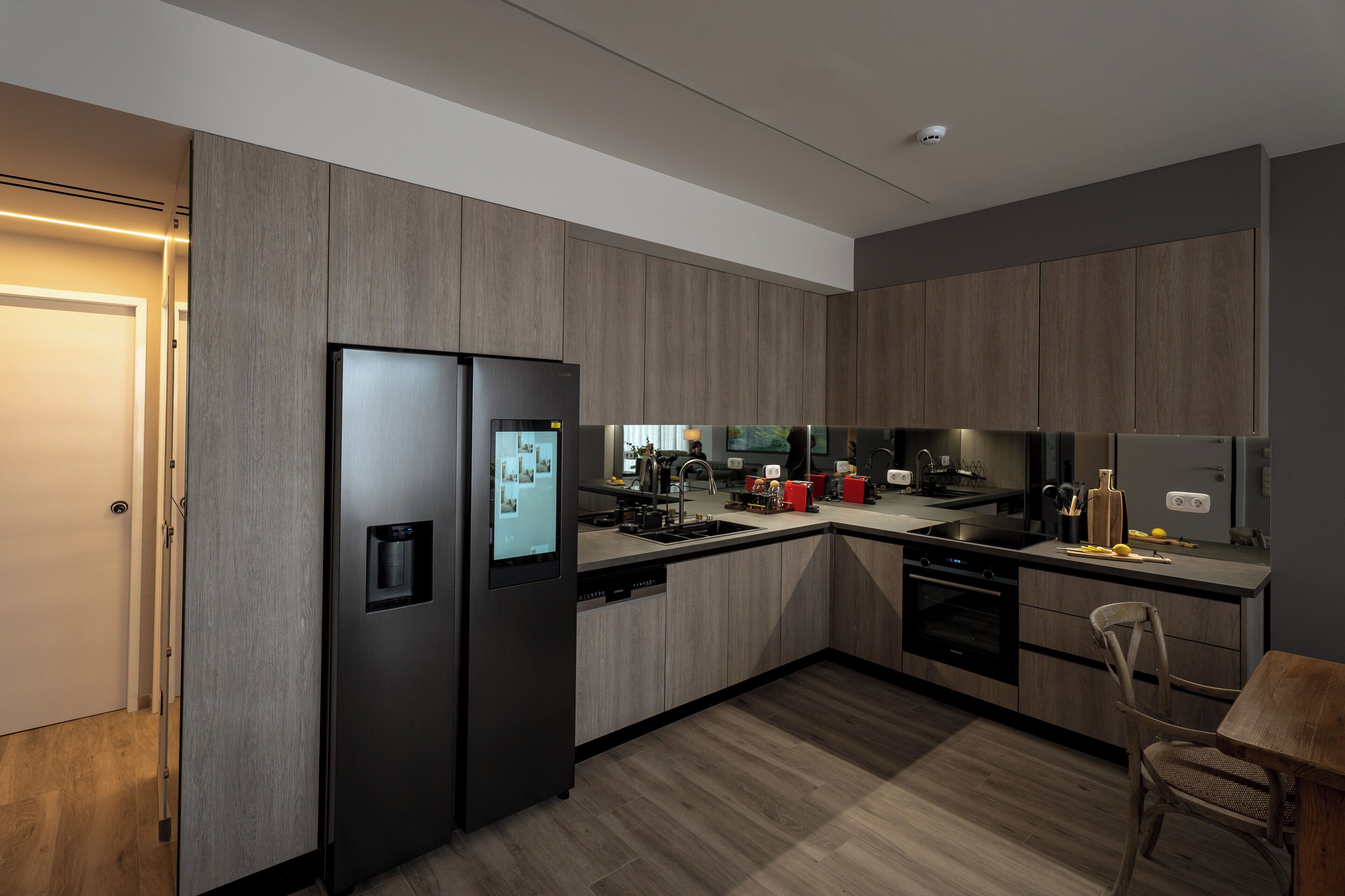 A modern kitchen with built-in appliances, a central island, and a dining area.
