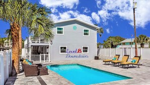 A two-story house with a pool, outdoor furniture, and a sign indicating 'Level B Downstairs'. - Lower Level 1 Block from 2 Beaches w/Private Pool, High-Speed Wi-Fi (St. Augustine)