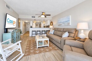 A spacious living room with a sofa, a coffee table, and a TV displaying 'Casaago Vacation Rentals'.