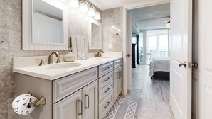 Een moderne badkamer met een grote spiegel, twee wastafels en een badmeubel met lades.