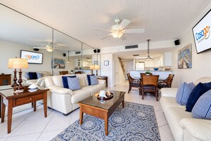 A modern living room with a sofa, coffee table, and dining area.