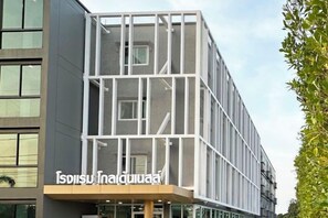 A modern building with a glass facade and a sign that reads 'Isosu Inn & Spa'. - Golden Nest Hotel Suvarnabhumi (Bangkok)