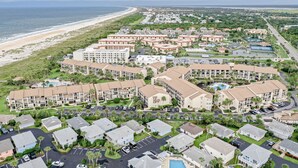 Ein Resort mit mehreren Gebäuden, einem Strand und einem Poolbereich.