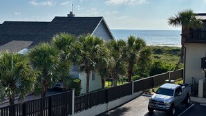 A residential area with a view of the ocean, palm trees, and a parked truck. - Oceanview condo with beach access, pool, tennis courts and private patio (St. Augustine)