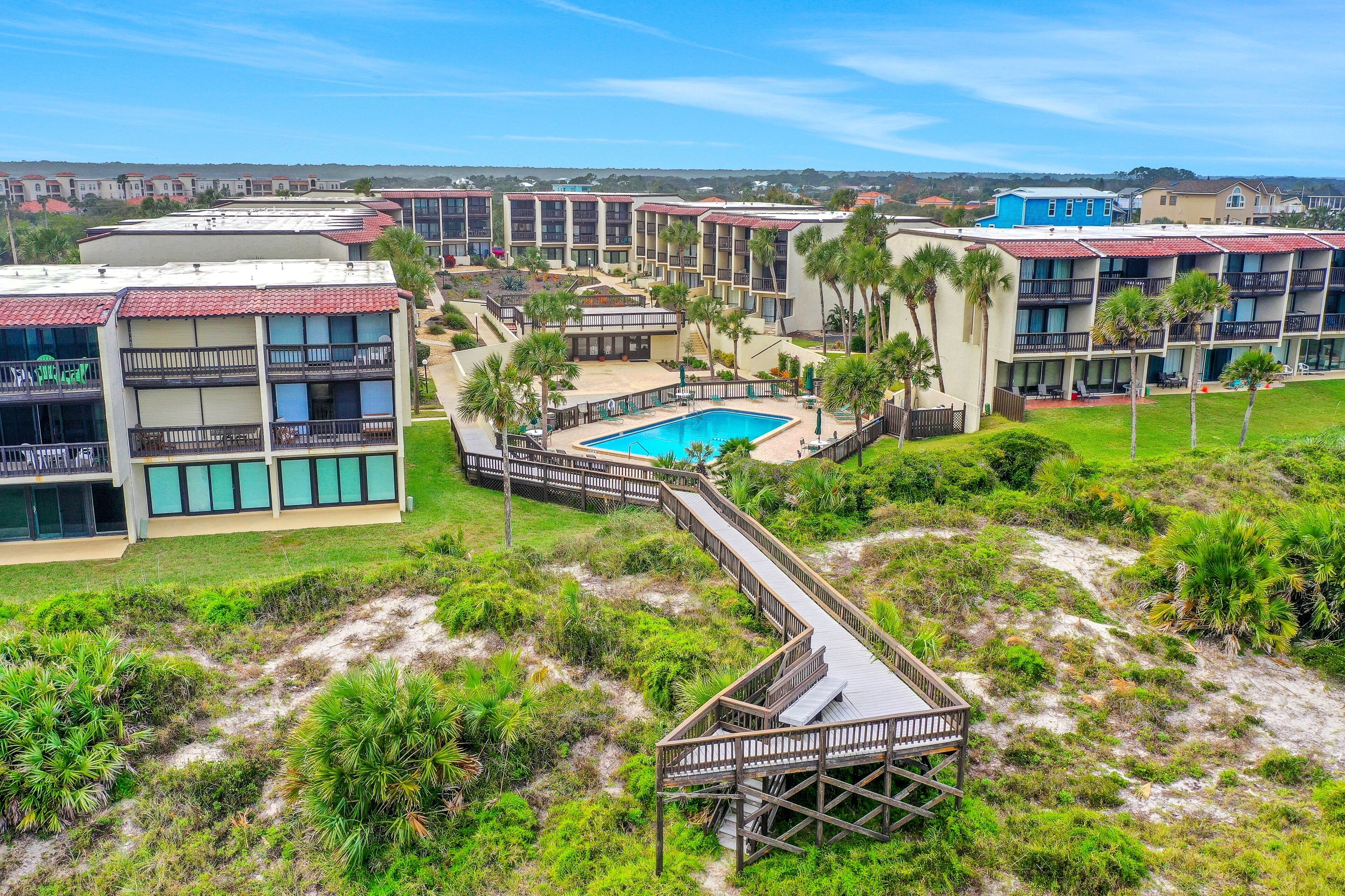 Ein Resort mit mehreren Gebäuden, einem zentralen Pool und einer Promenade.