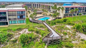 A resort with multiple buildings, a central pool, and a boardwalk. - Oceanview condo with beach access, pool, tennis courts and private patio (St. Augustine)