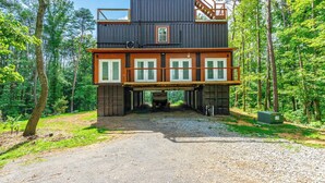 Eine Hütte mit zweistöckiger Bauweise, großen Fenstern und einem überdachten Eingang.