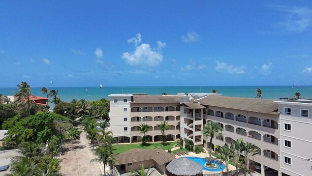A resort with multiple-story buildings, a swimming pool, and a view of the ocean. - Hosts BR - Vista Mar no Cumbuco  (Caucaia)